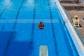 Young  swimmer jumping from starting block in a swimming pool Royalty Free Stock Photo