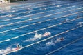 Young swimmers in outdoor swimming pool during freestyle race. Health and fitness lifestyle. Royalty Free Stock Photo