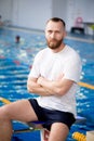 A young swimming coach near the sports pool.