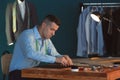 Young tailor marking fabric with chalk in atelier Royalty Free Stock Photo