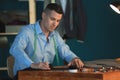 Young tailor marking fabric with chalk in atelier Royalty Free Stock Photo