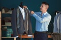 Young tailor taking measurements of jacket on mannequin in atelier Royalty Free Stock Photo