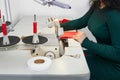 Young tailor using professional overlock sewing machine in workshop studio. Equipment for edging, hemming or seaming