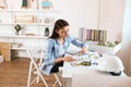 Young talented achitect using compasses while drawing a model of building