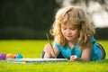 Young talented boy artist painter. Portrait of smiling happy kid enjoying art and craft drawing in backyard or spring Royalty Free Stock Photo