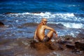 Young tanned guy on the Rocky seashore Royalty Free Stock Photo