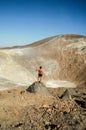 Young tanned male model posing in front of a volcano crater
