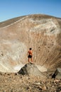 Young tanned male model posing in front of a volcano crater