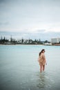 Young tanned woman crossing blue water at seaside Royalty Free Stock Photo
