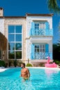 young man at an swimmingpool with red pink flamingo,pink flaming by the pool