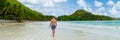 young tanning men in swim short at a white tropical beach Anse Volbert beach Praslin Seychelles