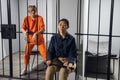 A young taskmaster in uniform sits on a chair next to the camera of a blonde criminal Royalty Free Stock Photo