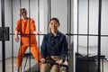 A young taskmaster in uniform sits on a chair next to the camera of a blonde criminal Royalty Free Stock Photo