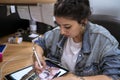 Young tattoo artist drawing her new design on the tablet.