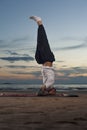 Young tattoo man practicing yoga headstand pose