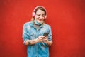 Young tattoo woman listening playlist music with mobile phone app - Young woman using device gadgets wearing safety mask during