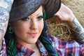 Young tattooed stylish woman in cowgirl style