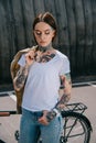 young tattooed woman with closed eyes holding jacket over shoulder Royalty Free Stock Photo