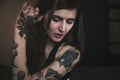 Young tattooed woman with long hair poses