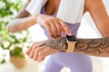 Young tattooed woman looking at activity fitness tracker during workout break, checking heart rate and burned calories Royalty Free Stock Photo