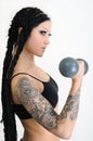 young tattooed woman with old dumbbells