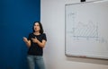 Young teacher explaining a concept with graph on whiteboard Royalty Free Stock Photo