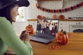 Happy woman in front of computer screen having online Halloween party with children Royalty Free Stock Photo