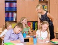 Young teacher helps students of primary school in the exam Royalty Free Stock Photo