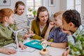 Young teacher with model of wind turbine learning pupils about wind energy. Royalty Free Stock Photo