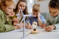 Young teacher with model of wind turbine learning pupils about wind energy. Royalty Free Stock Photo