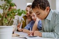 Young teacher with model of wind turbine learning pupils about wind energy. Royalty Free Stock Photo