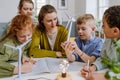 Young teacher with model of wind turbine learning pupils about wind energy. Royalty Free Stock Photo