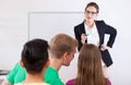 Young teacher pointing on talking student Royalty Free Stock Photo