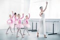 young teacher practicing ballet with adorable kids in pink