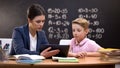 Young teacher showing schoolboy information on tab, private lesson, innovations