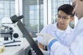 Young teacher and student boy use microscope in science class at laboratory Royalty Free Stock Photo