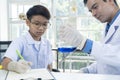 Young teacher and student boy use microscope in science class at laboratory Royalty Free Stock Photo