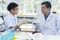 Young teacher and student boy use microscope in science class at laboratory Royalty Free Stock Photo