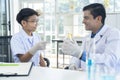 Young teacher and student boy use microscope in science class at laboratory Royalty Free Stock Photo