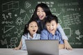 Young teacher and students look at laptop Royalty Free Stock Photo