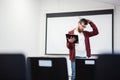 Young teacher thinking in empty classroom Royalty Free Stock Photo
