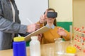 Young teacher using Virtual Reality Glasses and 3D presentation to teach students in chemistry class.Education, VR, New technology