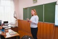 Young teacher woman in front of the class at the blackboard