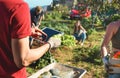 Young team pick up organic vegetables from inside eco village while planning season harvest for local market - Focus on man hand