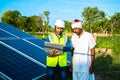 young technician checks the maintenance of the solar panels and discussing with farmer at field,