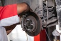 Young technician fixing brake disk in car garage Royalty Free Stock Photo