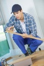 Young technician installing floor at construction site Royalty Free Stock Photo