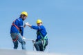 A young technician intern working on solar panels is fear of heights with senior engineers