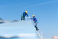 A young technician intern working on solar panels is fear of heights with senior engineers