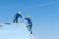 A young technician intern working on solar panels is fear of heights with senior engineers